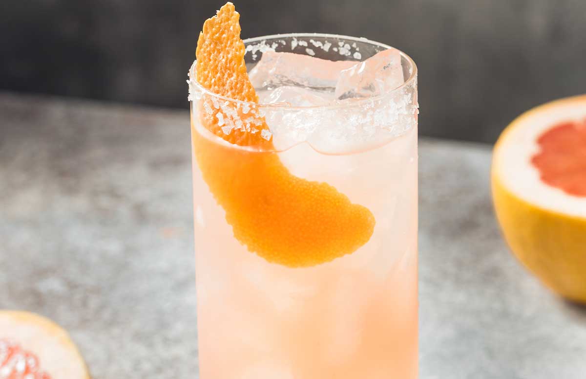 grapefruit mezcal cocktail in a large glass with salted rim