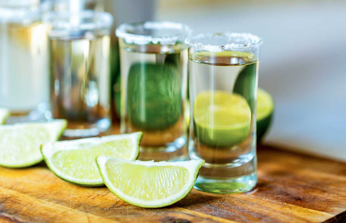 shot glasses of joven tequila and lime wedge