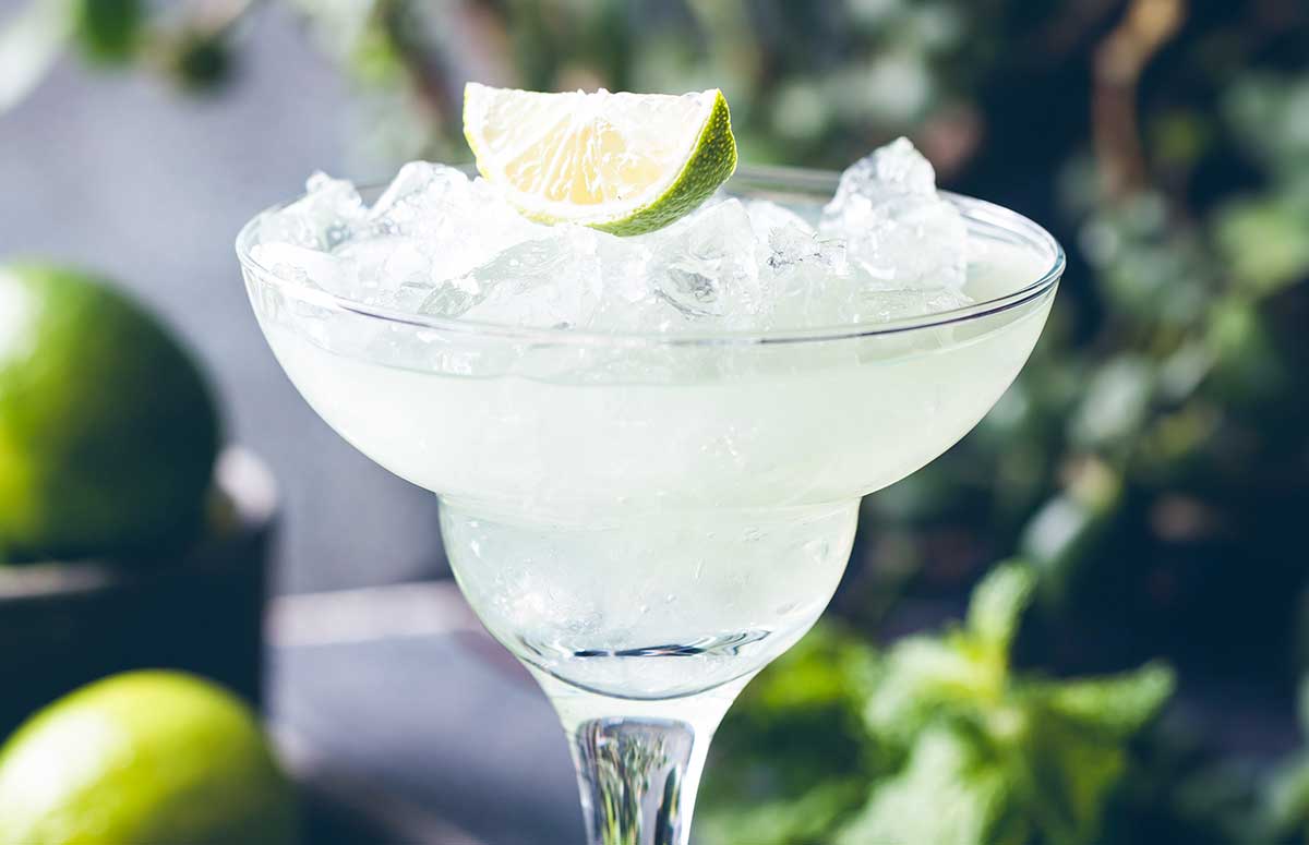 cadillac margarita in a glass with a lime wedge