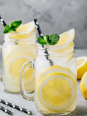 two glasses of tequila lemonade and some lemons around