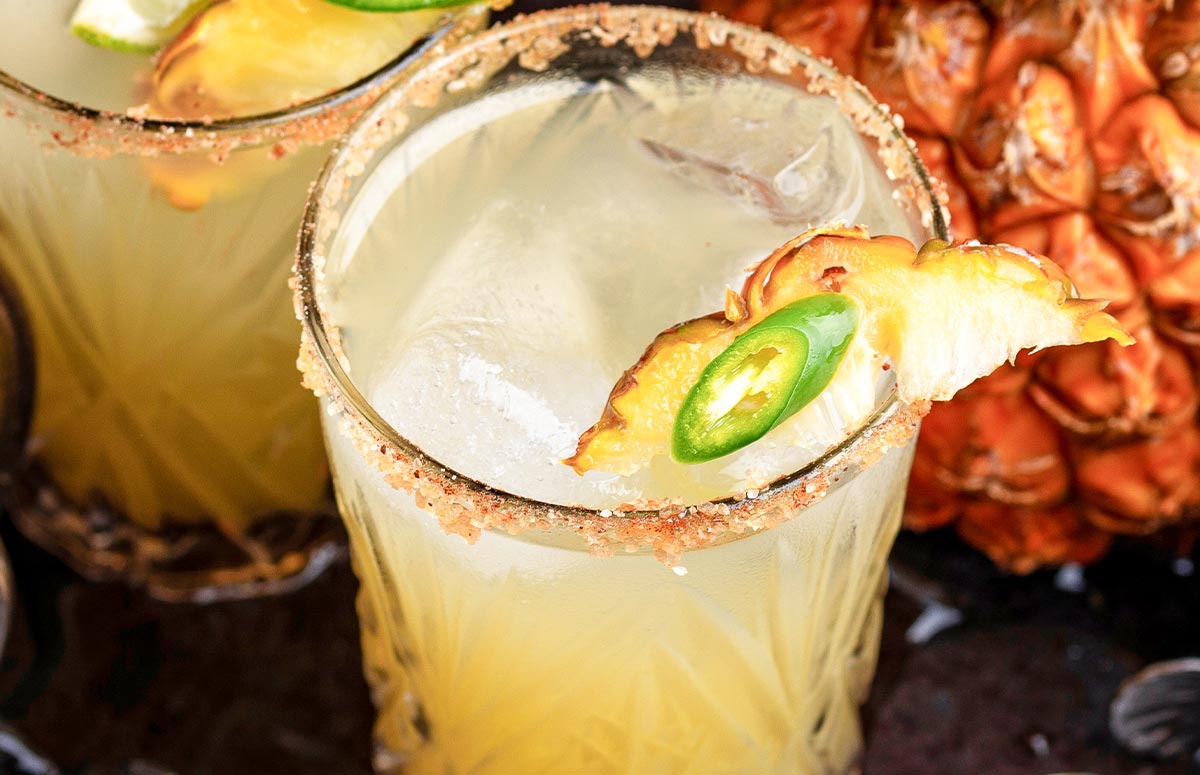 a glass of pineapple jalapeño margarita