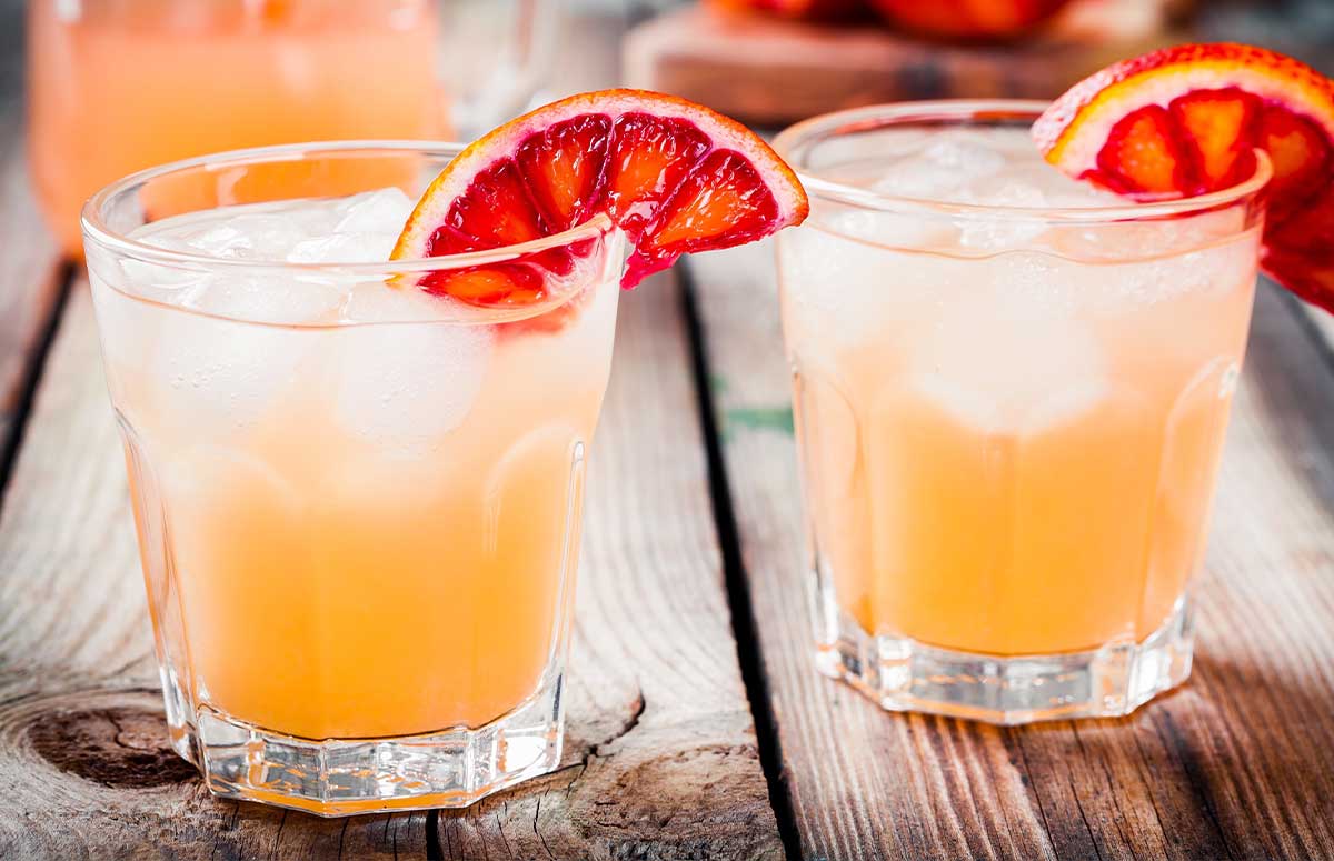Two glasses of Blood Orange Margarita with sliced blood orange garnish.