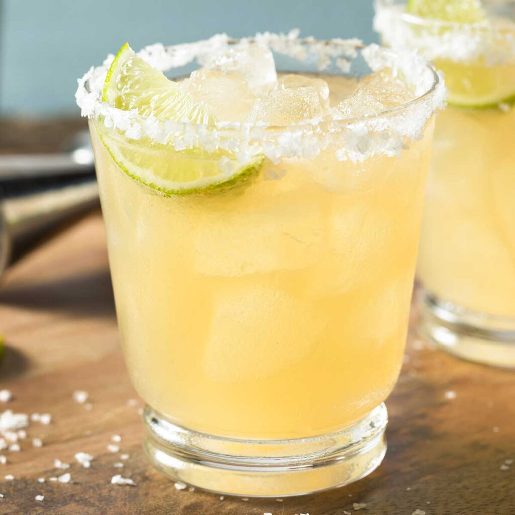 skinny margarita in a glass with a slated rim and a lime wedge