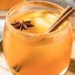 Apple Pie Margarita in a glass rimmed with cinnamon sugar and garnished with a cinnamon stick