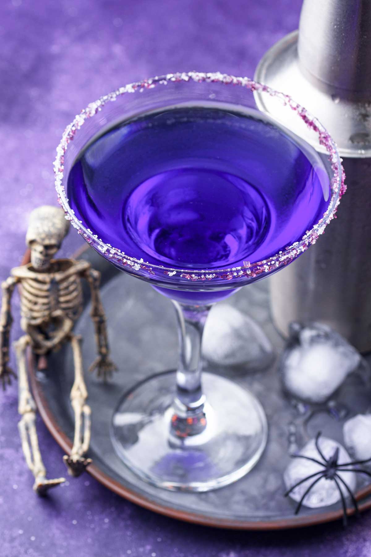 purple halloween margarita cocktail inside a sugary rimmed glass