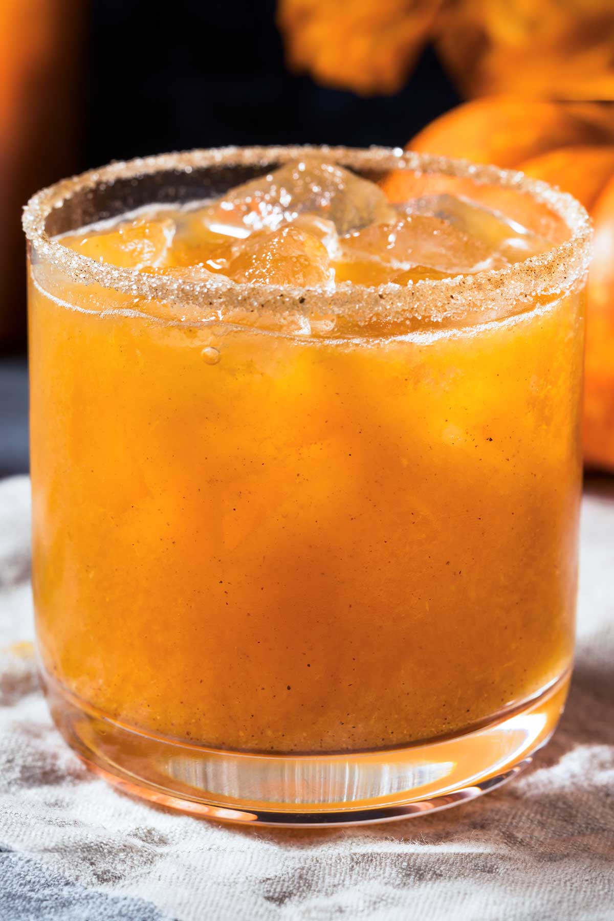 short glass of a pumpkin margarita with cinnamon sugar on the rim