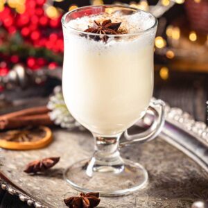 closeup of Eggnog & tequila drink in a glass with a cinnamon garnish