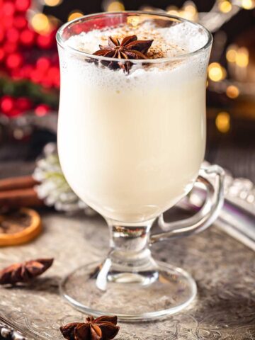 large glass of eggnog and tequila with Christmas garnish