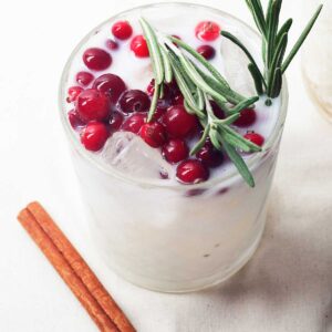 white margarita topped with cranberries and rosemary