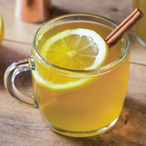 tequila hot toddy in a glass mug with lemon and cinnamon