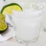 a small glass of a margarita with a wedge of lime
