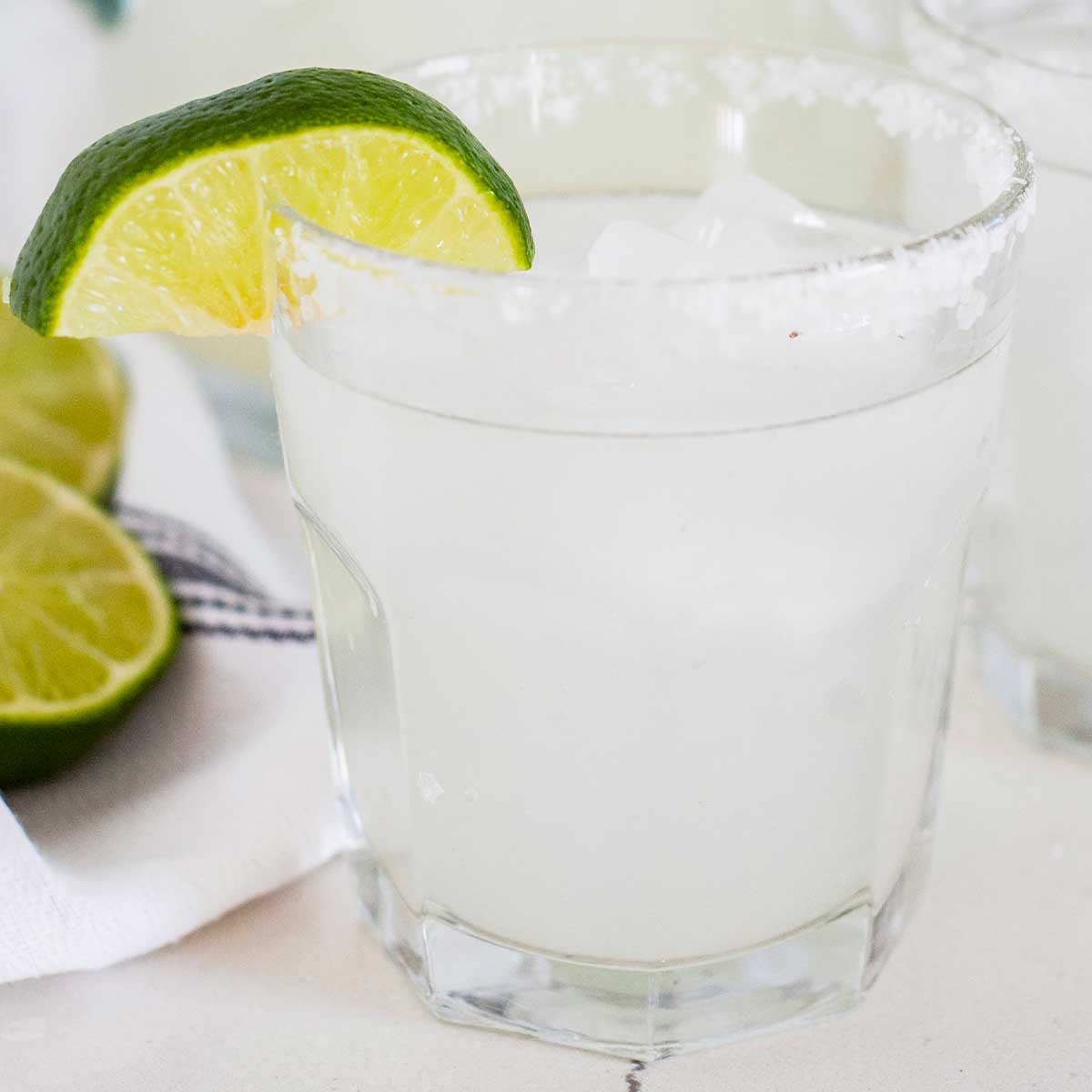 a small glass of a margarita with a wedge of lime