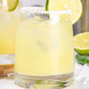 2 glasses of mezcal margarita with salt and lime on the rim.