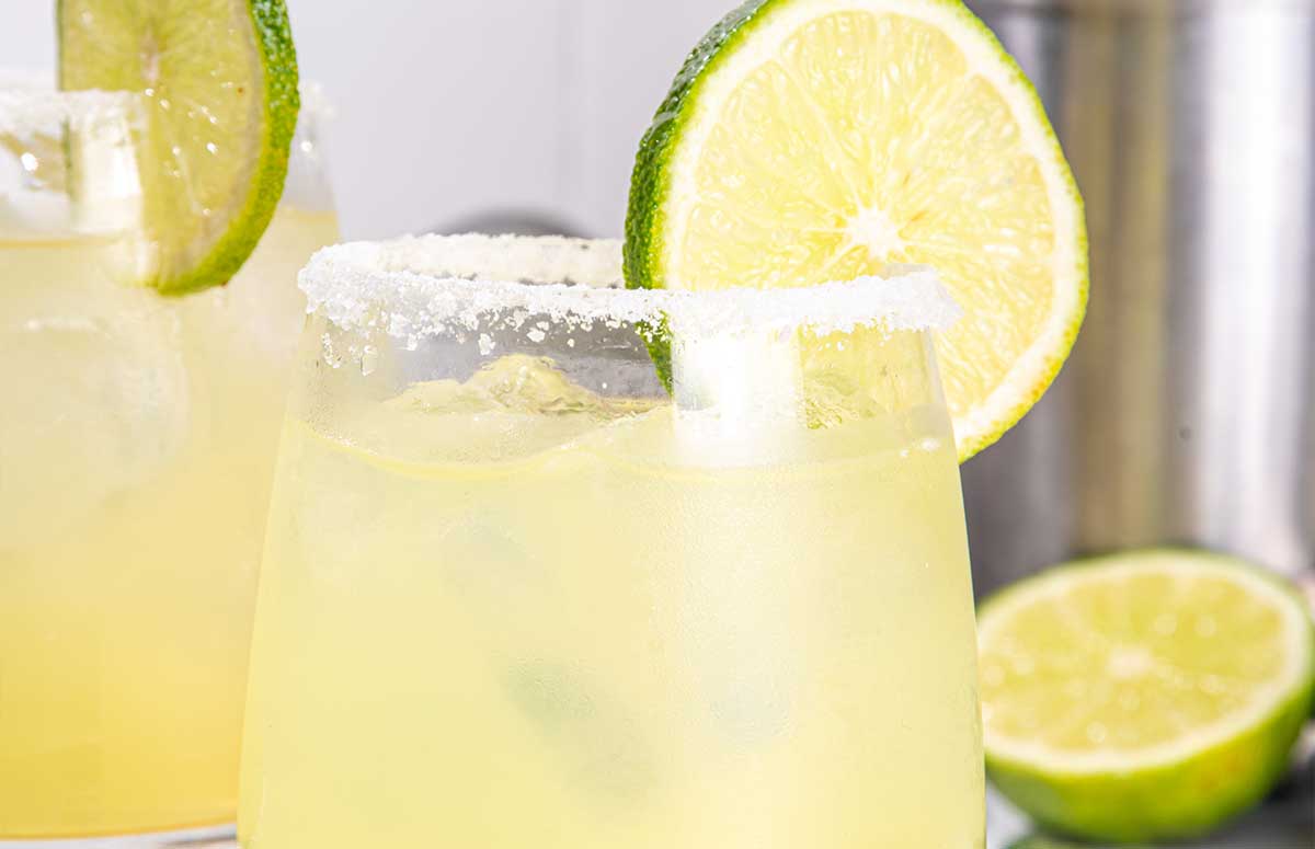 closeup of a mezcal margarita with a slice of lime 