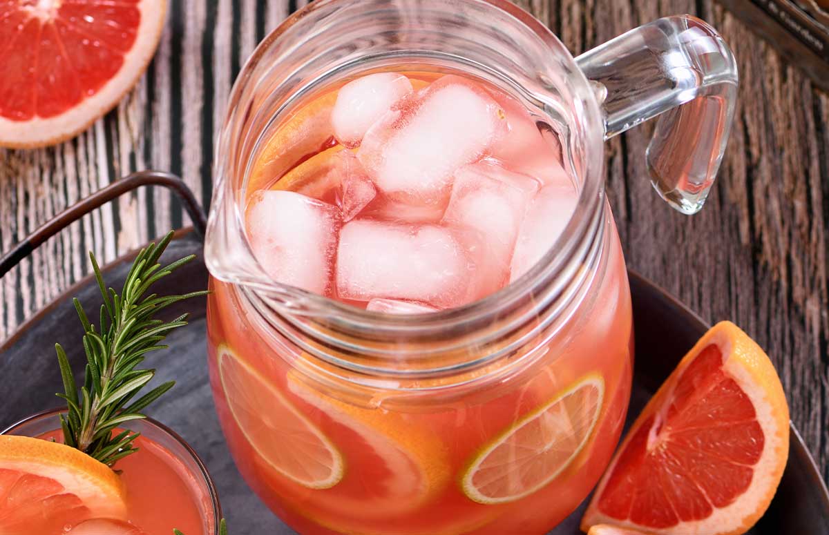 a pitcher of paloma with sliced grapefruit