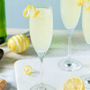 Tequila Champagne Cocktail in a champagne glass with a lemon twist garnish