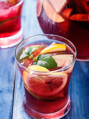 A glass of tequila sangria with lemon and lime slices