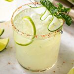Spicy cucumber margarita in a glass with ice and cucumber slices