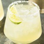 Elderflower Margarita with salted rim and lime wedge.