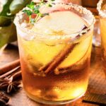 Fall Margarita with a brown sugar rim, apple slices, and cinnamon sticks.