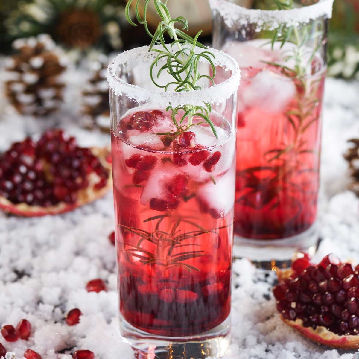 Christmas cocktail with tequila, with a salted rim, thyme, and pomegranate seeds.