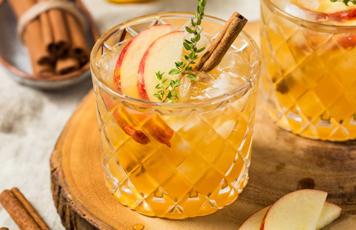 cinnamon margarita with apple slices and cinnamon sticks.