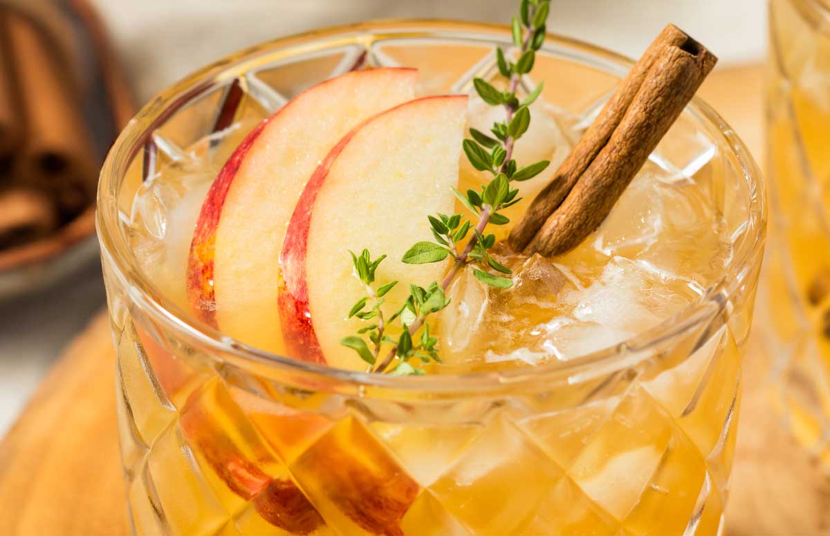 cinnamon margarita with apple slices and cinnamon sticks.