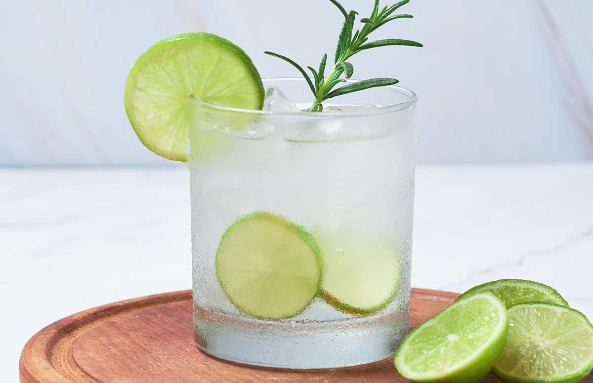 Rosemary Margarita with rosemary sprig and lime wedges.