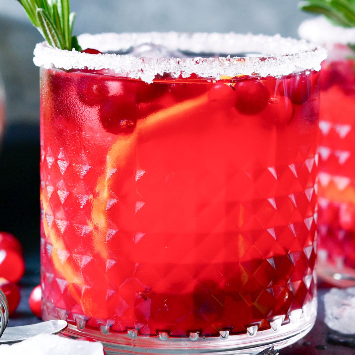 skinny Christmas Margarita with a sugared rim, orange slices, and cranberries.