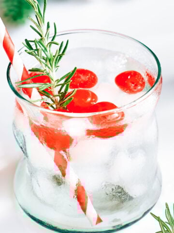 skinny Santa cocktail with rosemary sprig and maraschino cherries.