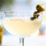dirty margarita with cocktail olives skewered on a cocktail pick
