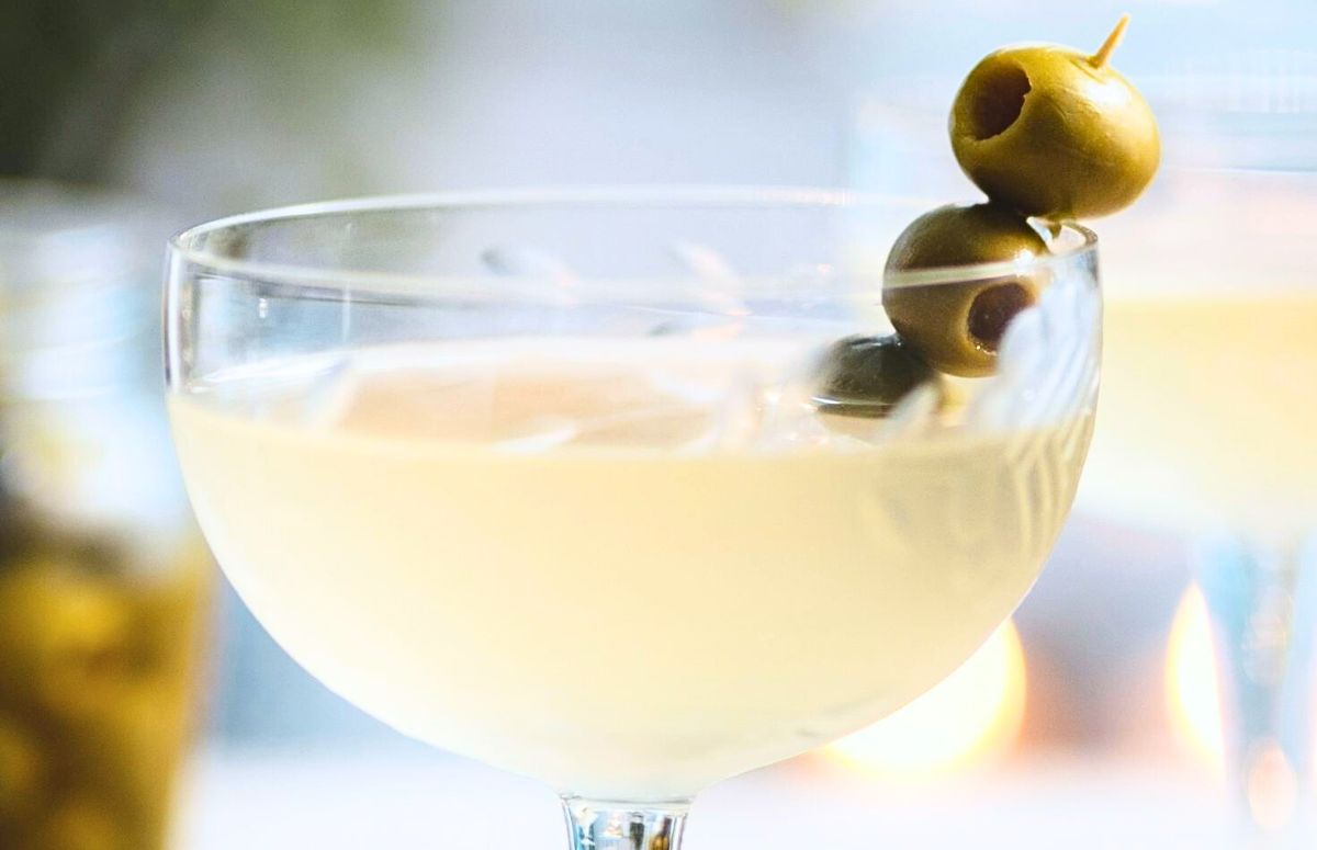 dirty margarita with cocktail olives skewered on a cocktail pick
