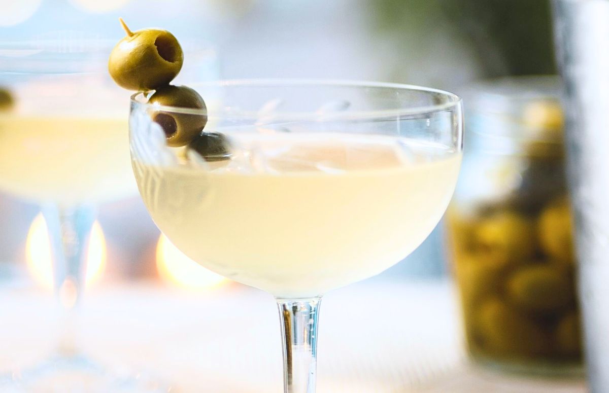 dirty margarita with cocktail olives skewered on a cocktail pick