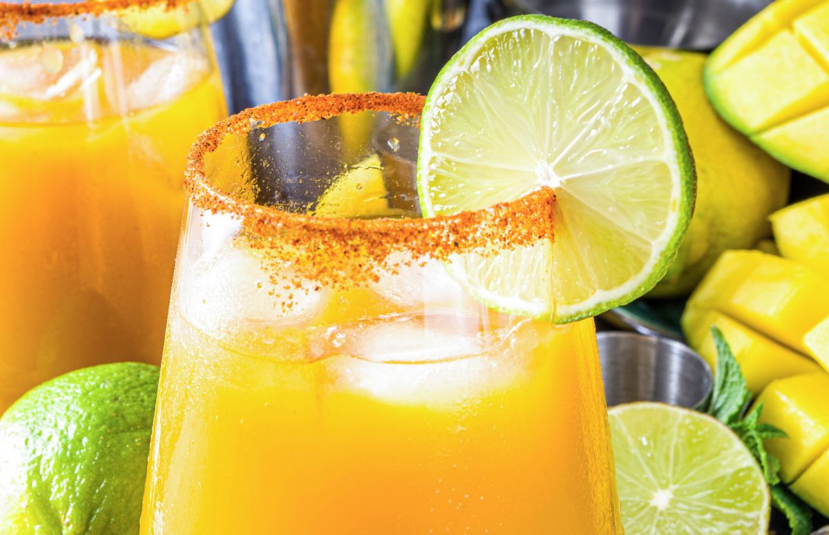 spicy mango margarita with tajin and lime slice