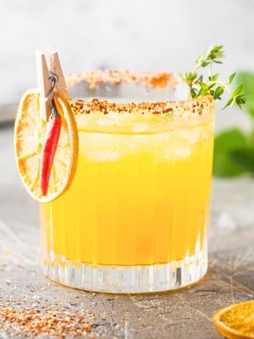 spicy orange margarita in a tajin rimmed glass