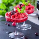 two frozen berry margaritas garnished with mint leaves