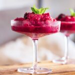 a raspberry frozen margarita in a tall stem glass
