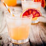 Blood orange tequila cocktail with a striped orange straw