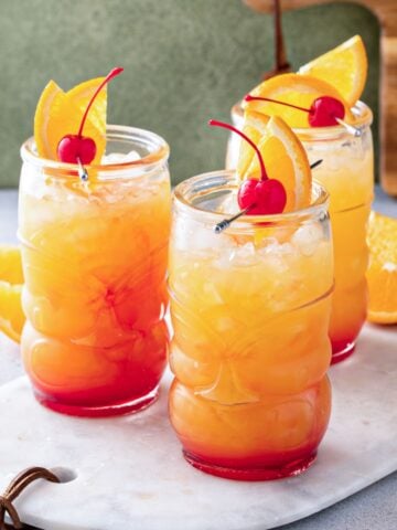 three tall glasses of a fruity tequila punch