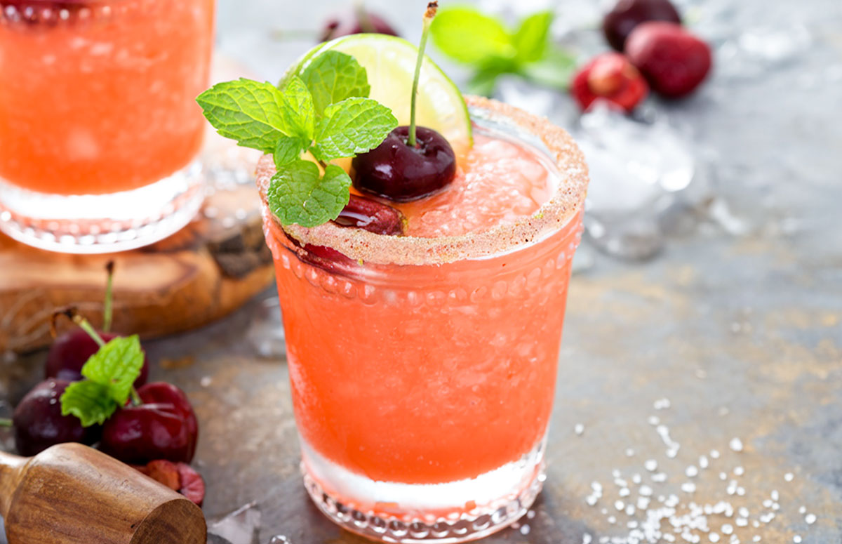a glass of frozen cherry limeade margarita