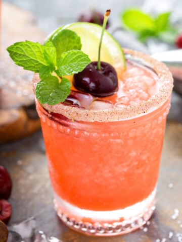 a glass of frozen cherry limeade margarita